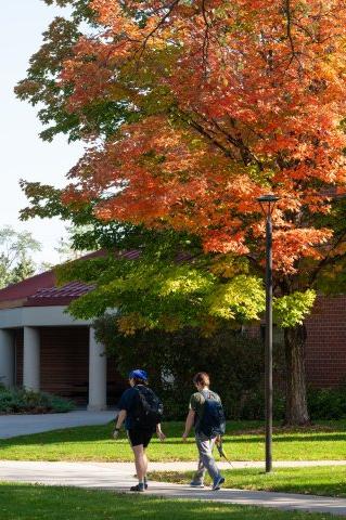 Two students walking on campus in the fall